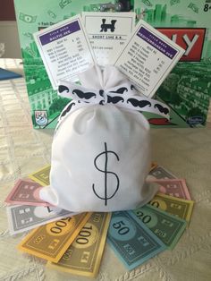 a bag filled with lots of money sitting on top of a table next to some cards