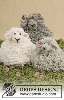 three crocheted sheep sitting next to each other on top of a green blanket