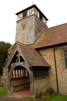 an old building with a clock on the top of it's steeple and arched doorway