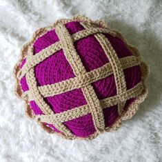 a ball of yarn sitting on top of a white blanket covered in crochet