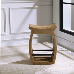 a wooden stool sitting on top of a white carpeted floor next to a window