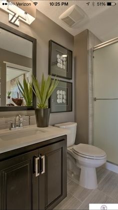 a bathroom with a toilet, sink and shower in it's own home area