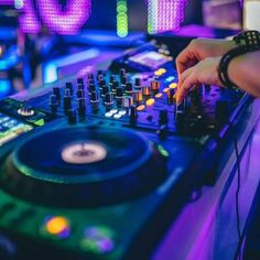 a dj mixing music in front of colorful lights