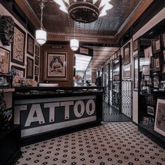 the inside of a tattoo shop with lots of pictures on the walls and flooring