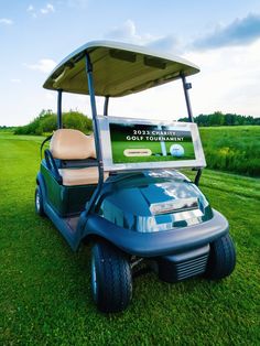 a blue golf cart parked in the grass