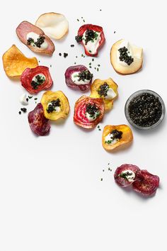 an assortment of fruits and vegetables on a white surface with some black stuff in the middle