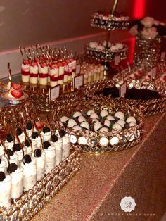 an assortment of desserts and pastries displayed on a buffet table at a party