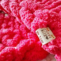 a close up of a pink blanket with a tag attached to it's end