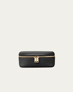 a black and gold cosmetic case on a white background