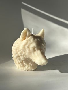 a candle that is shaped like a dog's head on a white tablecloth