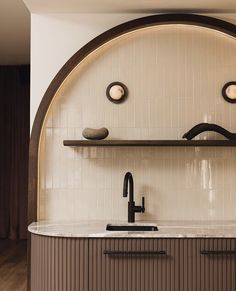 a kitchen with a sink, shelves and lights on the wall above it's countertop