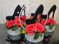 three silver vases with red roses and black high heels