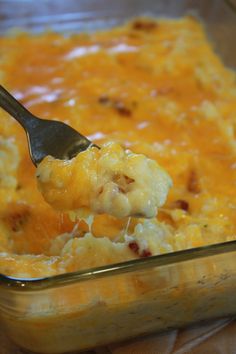 a spoon full of macaroni and cheese in a casserole dish