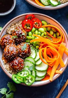 two bowls filled with meatballs and vegetables next to dipping sauces on the side