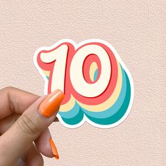 a hand holding an orange sticker with the number ten on it