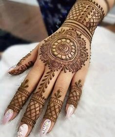 a woman's hand with henna tattoos on it