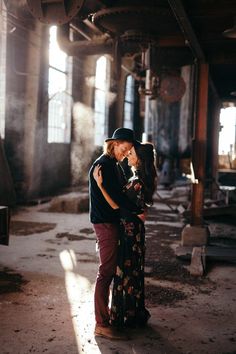 a man and woman embracing in an abandoned building