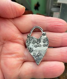 "This pendant charm is covered with musical notes. Perfect gift for a musically talented person. As with all my charms and pendants, this one is made of jewelry-grade pewter. It is designed, hand-casted and hand finished by me. Weight: 4 grams Size: 1 1/2\" tall, .87\" wide" Silver Heart-shaped Music-themed Jewelry, Music-themed Silver Heart Jewelry, Nickel Free Metal Heart Charms, Nickel-free Heart-shaped Metal Charms, Nickel-free Metal Heart Charms, Pendant Heart, Pewter Pendant, Musical Notes, Handmade Charms