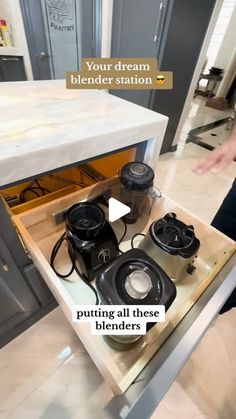 an open drawer in the middle of a kitchen with appliances on top and below it