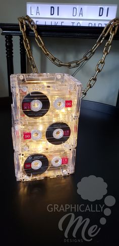 a cassette case with lights and chains hanging from it's sides