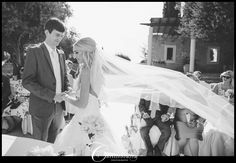 a bride and groom standing under a veil in front of their guests at a wedding