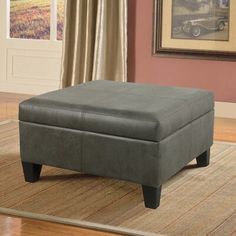 a gray ottoman sitting on top of a rug