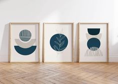 three framed art prints on the wall in an empty room with wood floors and parquet flooring