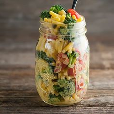 a mason jar filled with pasta and vegetables