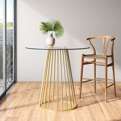 a table with a vase on it next to a wooden chair and glass top table