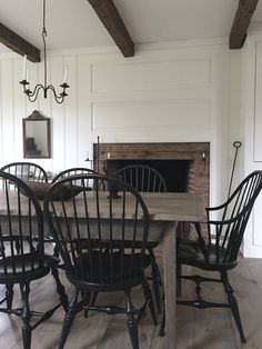 a dining room table with four chairs and a fire place in the fireplace behind it