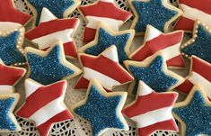 decorated cookies with red, white and blue icing on a lace doily in the shape of stars