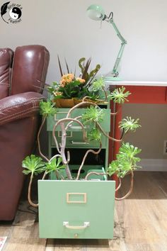 a green planter sitting on top of a table next to a brown leather chair