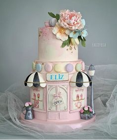 a pink and white cake with flowers on top