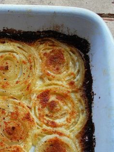 a casserole dish is shown with cinnamon rolls in the center and topped with cheese