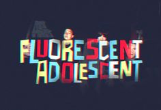 the words fluorescent adolescentn are projected on a black background with multicolored letters