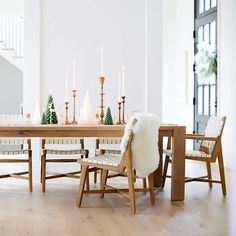 a dining room table with chairs and candles