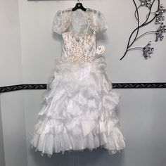 This Kids Dress Features Beautiful Jewel Accents, A Fluffy Skirt, Matching Bolero Jacket, With Back Corset Closure. White Short Sleeve First Communion Dress For Pageant, Short Sleeve Ruffled Princess Dress For Pageant, White Ruffled Pageant Dress For First Communion, White Princess Pageant Dress With Ruffles, White Princess Dress With Ruffles For Fancy Dress, White Pageant Dress With Ruffles, Princess Style White First Communion Dress With Ruffles, White Ruffled Dress For Fancy Dress, White Ruffled Dress For Fancy Dress Occasion