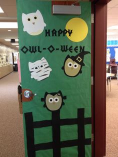 a green door decorated with halloween decorations and stickers on it's side in an office hallway