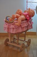 a baby doll sitting in a pink cradle