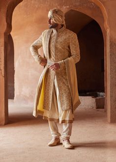 Editor's Note Radiate regal charm in our gold raw silk sherwani, meticulously adorned all over with tonal resham, kasab, dabka, and beadwork. Accompanied by a beige monga tussar kalidar kurta and churidar, this ensemble is a perfect blend of opulence and tradition. With its captivating craftsmanship and luxurious fabric, it's a choice that ensures you stand out on your special occasion. Note: Stole and belt are for styling purposes only. Fabric: Raw silk and monga tussar Color: Gold Components: Tiny Mirrors, Embroidered Sherwani, Groom Fashion, Sherwani Groom, Wedding Sherwani, Indian Groom, Mens Luxury Fashion, Kurta With Pants, Silk Organza