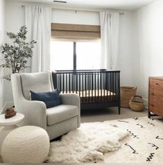 a baby's room with a crib, rocking chair and white rug on the floor