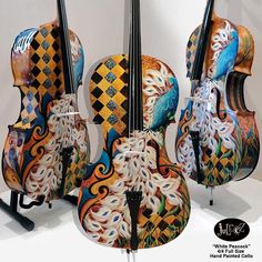 three colorfully painted cellos are on display