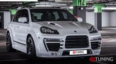 a white porsche cayen is parked in a parking garage with the license plate on it