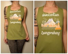 a woman wearing a green tank top with an image of a mountain on the back