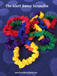 the giant dance scrunchie is colorfully colored and sits on a blue carpet