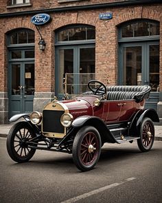 an old fashioned car parked in front of a brick building