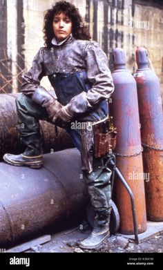 a young man is standing on top of pipes in the street - stock image