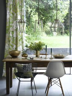 a dining room table with chairs and hanging lights