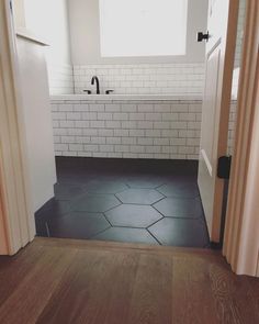 an open door leading to a bathroom with black and white tile