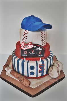 a three tiered cake with baseballs and hats on it's top layer